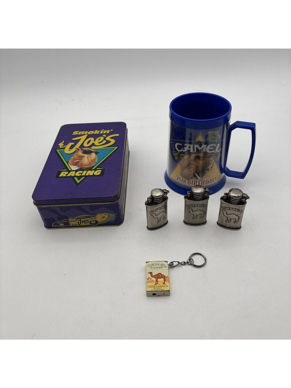 Vintage Joe Camel Cigarette Plastic Mug, Camel Tin, And 4 Camel Lighters.